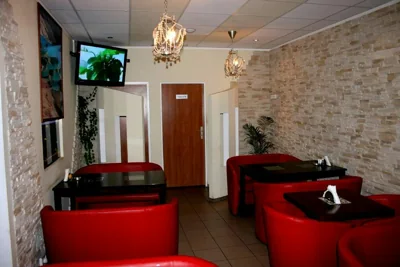 Stoliki i czerwone fotele we wnętrzu Sila Kebab